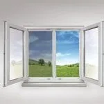 Doppelflügelfenster mit Insektenschutz öffnen sich nach innen und geben den Blick auf eine sonnige Graslandschaft frei.