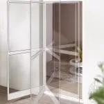 Eine moderne Eckschiebetür mit teilweise geöffnetem Insektenschutz führt in einen gut beleuchteten Raum mit zeitgemäßer Einrichtung.