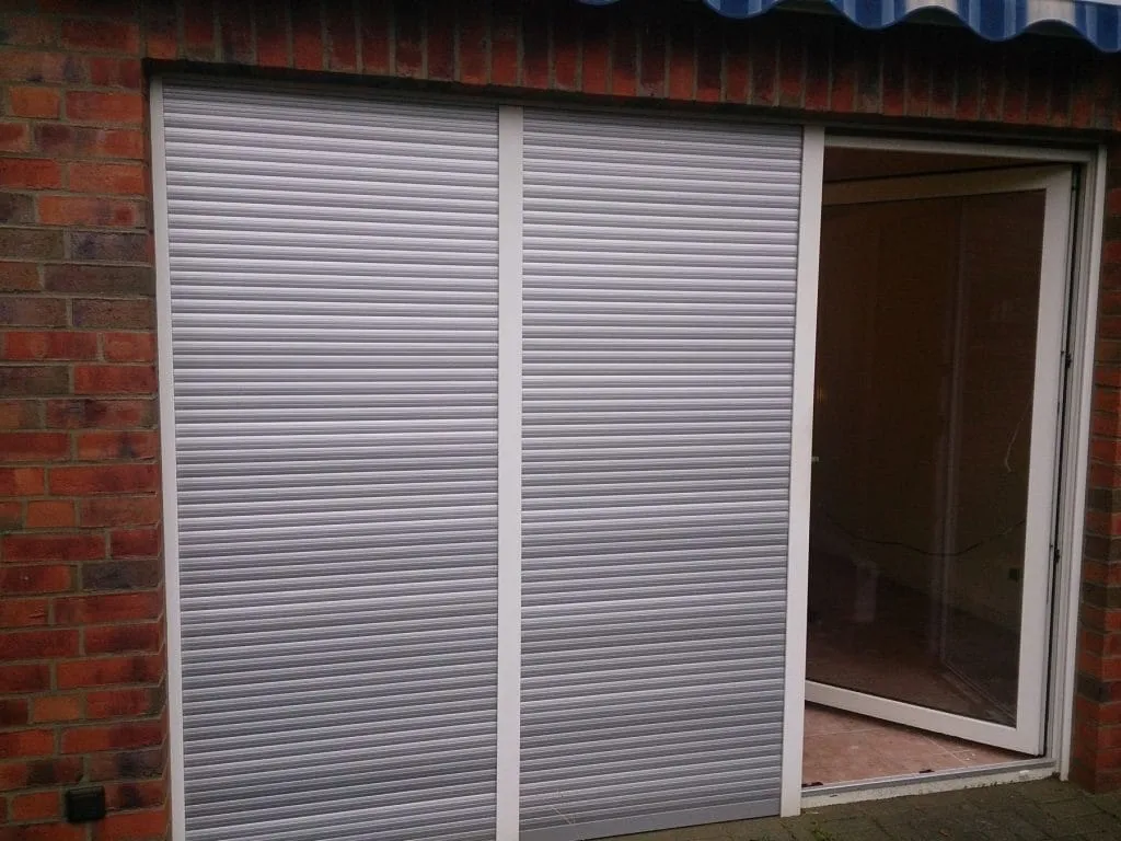 Schiebetür teilweise abgedeckt mit geschlossenem weißen Rollladen.