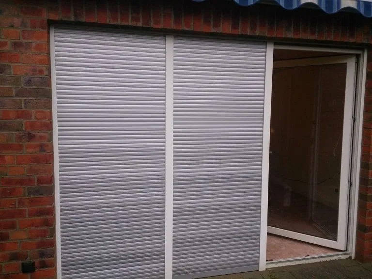 Schiebetür teilweise abgedeckt mit geschlossenem weißen Rollladen.